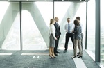 Geschäftsleute besprechen sich fröhlich in hellem Büro