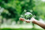 Hand-holding crystal globe with icon circular economy for carbon credit and CO2 emissions reduction.