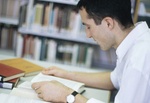 Mann liest Buch in einer Bibliothek *** Local Caption *** Uni Augsburg