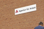 Mann sitzt ratlos vor Agentur fuer Arbeit