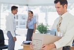 Mann trägt nach Kündigung seine Arbeitsmaterialien aus Büro